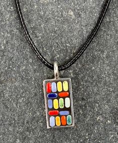 "Vibrant Multi-colored Pendant/Necklace -- Mosaic art pendant handcrafted from tiny ceramic Moroccan tiles in a rainbow of colors -- shades of red, blue, aqua, green, yellow and orange. These bright colors contrast against a backdrop of dramatic black, set in a brass overlaid with sterling silver (.925) rectangular frame. This pendant evokes a festive vibe that is casual and playful, but with a cool, mid-century modern design.  I love creating these unique pieces of jewelry! I play around with m Modern Multicolor Rectangular Jewelry, Artisan Multicolor Rectangular Necklace, Modern Handmade Multicolor Necklace, Modern Handmade Multicolor Necklaces, Modern Multicolor Pendant Necklace, Modern Multicolor Pendant Necklaces, Multicolor Rectangular Pendant Necklace For Gift, Unique Multicolor Rectangular Necklace, Rectangular Multicolor Necklaces As Gift