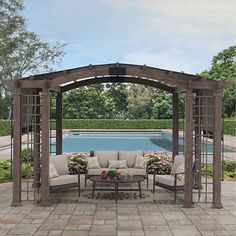 a gazebo with couches and tables in front of a swimming pool