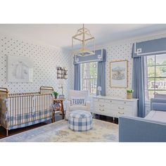 a baby's room with blue and white decor, including a crib, dressers, chair, and bed