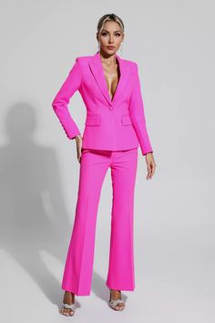 a woman in a bright pink suit posing for the camera with her hands on her hips