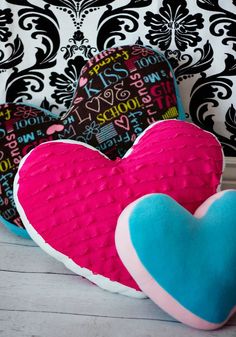 two heart shaped cushions sitting next to each other