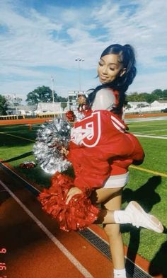 a cheerleader is posing on the sidelines