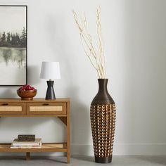 two vases sitting next to each other near a table with a lamp on it