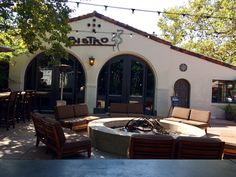 an outside seating area with chairs and fire pit in front of a building that says arito