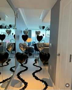 some balloons are in the shape of heart shaped hearts on a mirror surface with black streamers