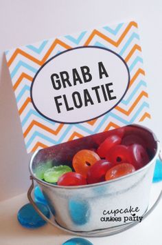 a bucket filled with gummy bears next to a sign that says grab a floatie