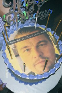 a man holding a cake with candles in front of him and the words happy birthday on it