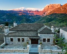 an aerial view of a house with mountains in the background