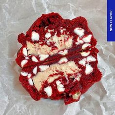 red velvet cake with white icing and marshmallows on top, sitting on wax paper