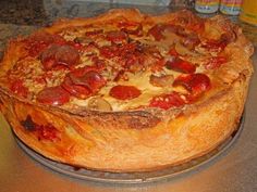 a pizza pie sitting on top of a metal pan covered in cheese and pepperoni