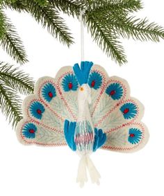 an ornament shaped like a peacock hanging from a tree