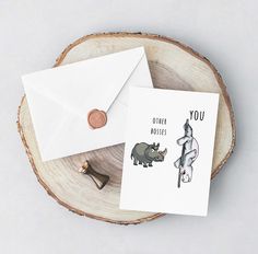 two greeting cards with rhinos on them sitting next to an envelope that says, you order roses