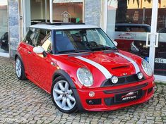 a red and white car parked in front of a building