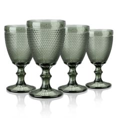 four glass goblets sitting next to each other