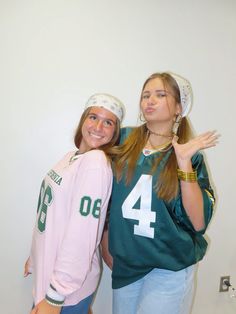 two young women posing for the camera in front of a wall