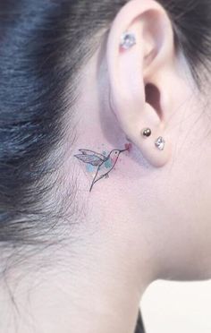 a woman with a tiny dragon tattoo on her ear