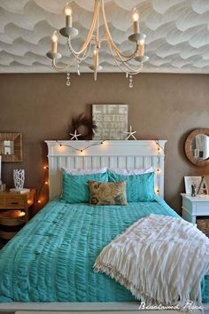 a bed with blue comforter and lights on the headboard, in a bedroom