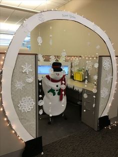 an office cubicle decorated for christmas with a snowman in the center and decorations on the wall