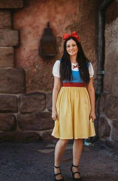 a woman dressed in snow white and yellow posing for the camera