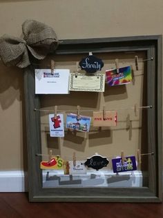 a bulletin board with clothes pins and magnets attached to it on a wooden floor