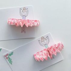 three pieces of folded paper with an image of a ballerina on one side and holly leaves on the other