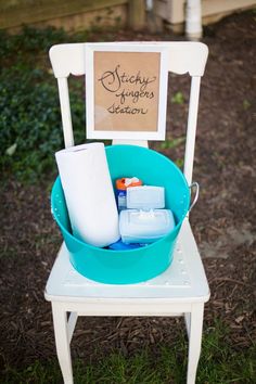 a chair with a sign on it and some toilet paper in the buckets inside