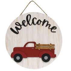 a wooden sign that says welcome with a red truck