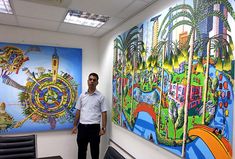 a man standing in front of paintings on the wall