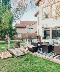 a dog is standing in front of a patio with furniture and games on the lawn