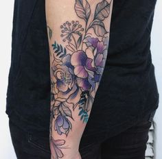 a woman's arm with flowers and leaves on it