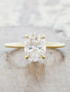 an oval cut diamond ring with two gold accents