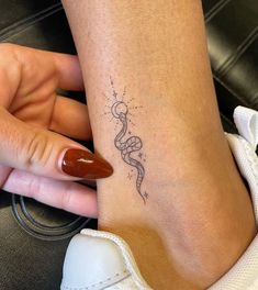 a woman's foot with a small tattoo on the left side of her leg