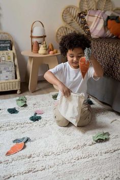 a little boy sitting on the floor playing with toys