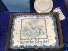 a baby shower cake with an elephant on the top and blue trimmings around it