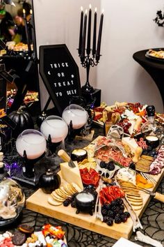 a table topped with lots of different types of food and candles on top of it