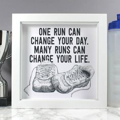 a framed poster with a pair of shoes on it next to a trophy and other items