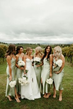 a group of women standing next to each other on top of a lush green field