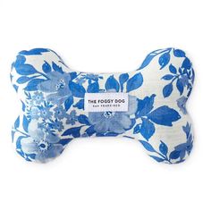 a blue and white floral dog bone toy on a white background with a tag that says the foggy dog