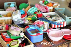 an assortment of toys sitting on top of a table next to boxes and containers filled with food