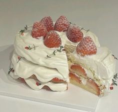 a cake with white frosting and strawberries on top