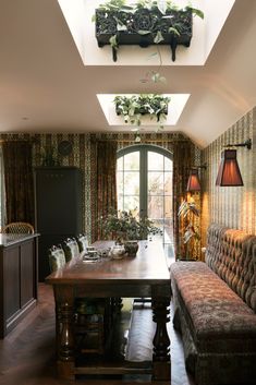 a living room filled with furniture and lots of plants on top of the windowsill