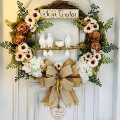 a wreath with birds and flowers hanging on a door