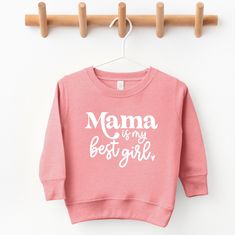 Mama is my best girl toddler sweatshirt  All sweatshirts are made with a cozy fleece lined unisex style pullover. Sizes range from 2T to 7 in this particular color.  SHIPPING: All orders will be shipped using USPS ground shipping (2-5 business days) unless you have upgraded. I always aim to get your items out as quickly as possible but if you need something to arrive by a certain time please message me and I'll do my best. SOCIAL MEDIA:   Follow me on Instagram to be the among the first to see new items and snag discounts @thechelleshoppe.  I absolutely love seeing how you style your shirts so please feel free to tag me! **CARE INSTRUCTIONS** To ensure the shirt and its design maintain a quality appearance please be sure to wash inside out in a cold setting. Tumble dry on low heat and do n Mother's Day Pink Cotton Sweatshirt, Pink Cotton Sweatshirt For Mother's Day, Cute Long Sleeve Tops For Mother's Day, Pink Long Sleeve Sweatshirt With Name Print, Cute Fleece Sweatshirt With Letter Print, Cute Long Sleeve Tops, Moms Best Friend, Toddler Girl Outfits, Kids Sweatshirt