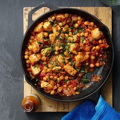 a pan filled with chickpeas and spinach on top of a cutting board