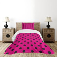 a pink and black polka dot comforter set with two lamps on the nightstands