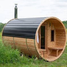 a wooden sauna in the middle of a grassy field