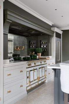 a large kitchen with white cabinets and gold trim on the doors, counter tops and drawers