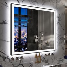 a bathroom vanity with a large mirror and lights on the wall above it, in front of a cityscape