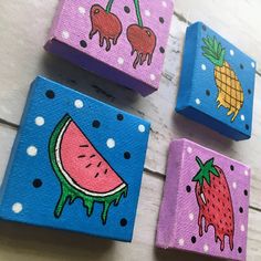 four painted wooden blocks with fruit on them