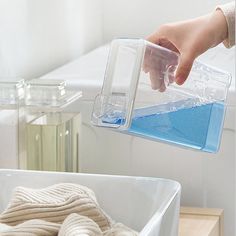 a person is pouring water into a container